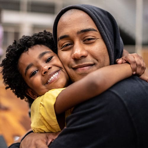 Adult male hugging male child