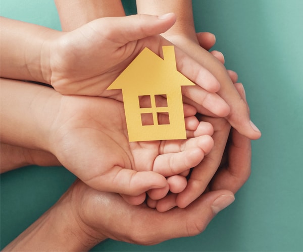 Hands holding cut out of a house